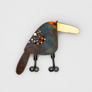 oxidized silver bird pin with gold beak, circle cut outs and orange and white spots
